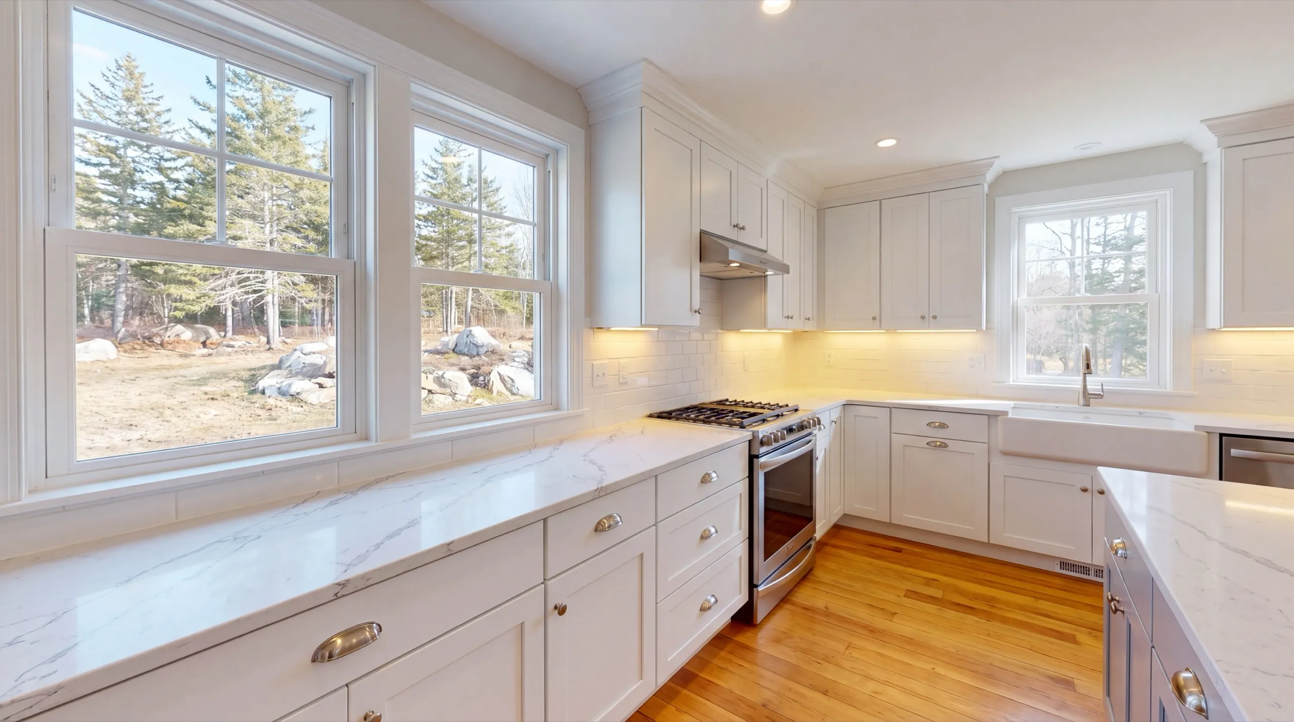 Remodeling Central Maine: white shaker kitchen with marbled stone counters, farmhouse sink and gas range