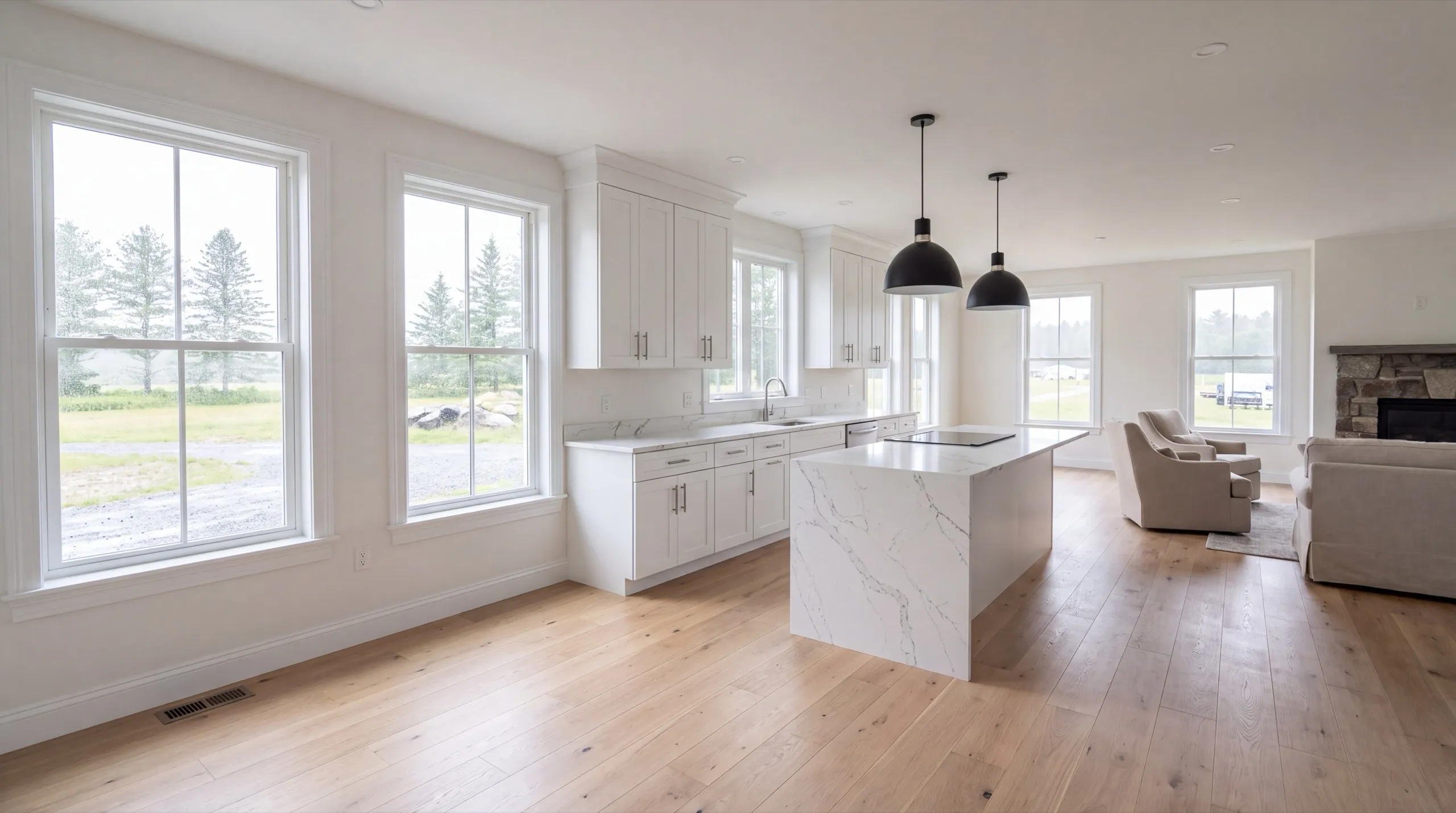 Remodeling in Windsor, ME: finished white kitchen with a stone island open to a living room