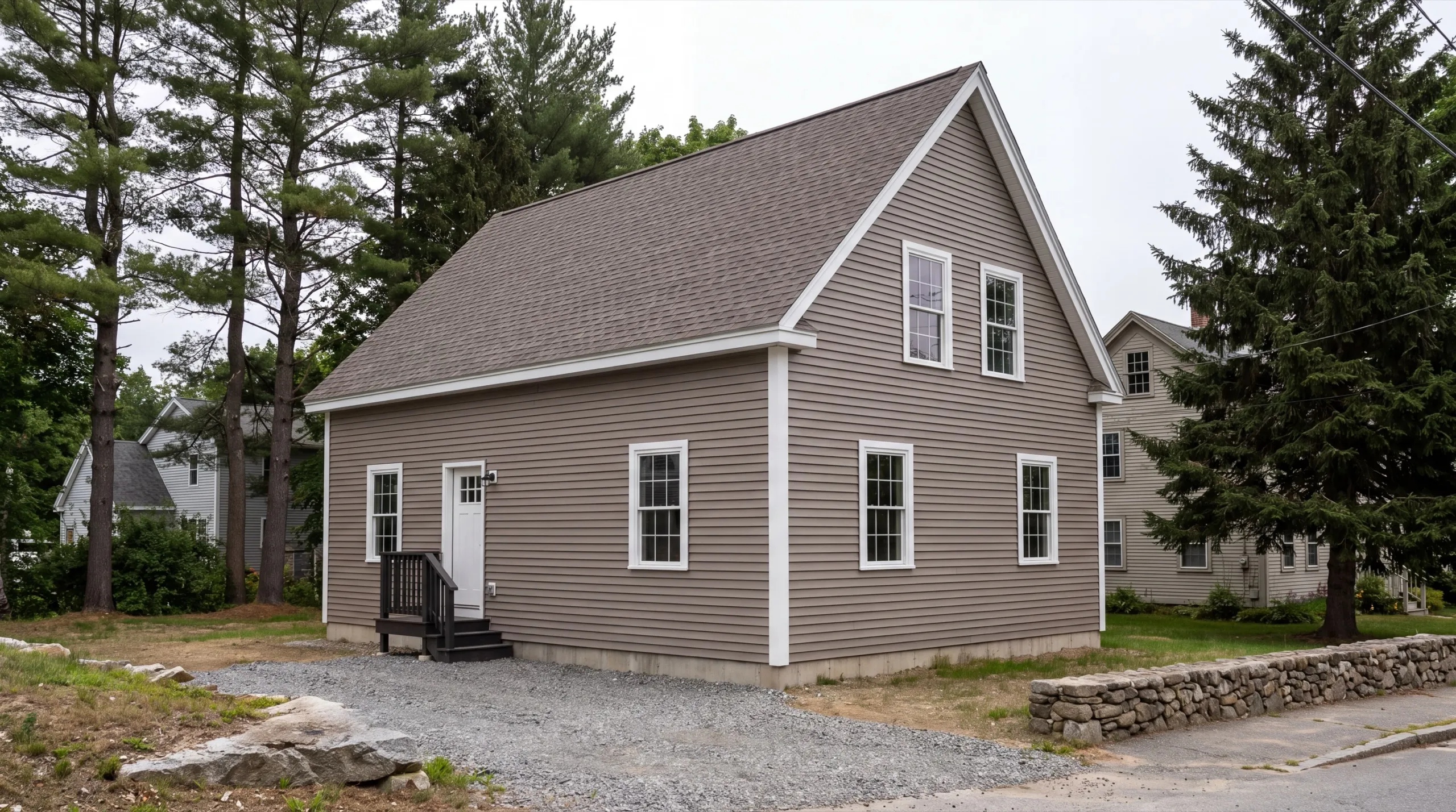 Siding contractor in Hallowell, ME: finished taupe cape with vinyl siding and a black entry stair