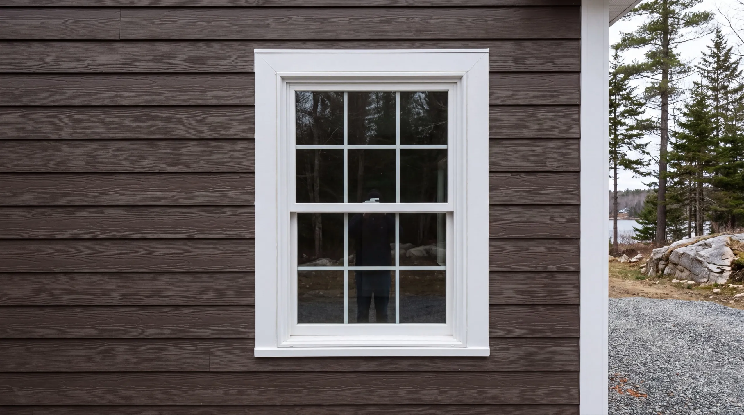 Siding installer Jefferson Maine: brown lap siding around a white window casing beside a corner board