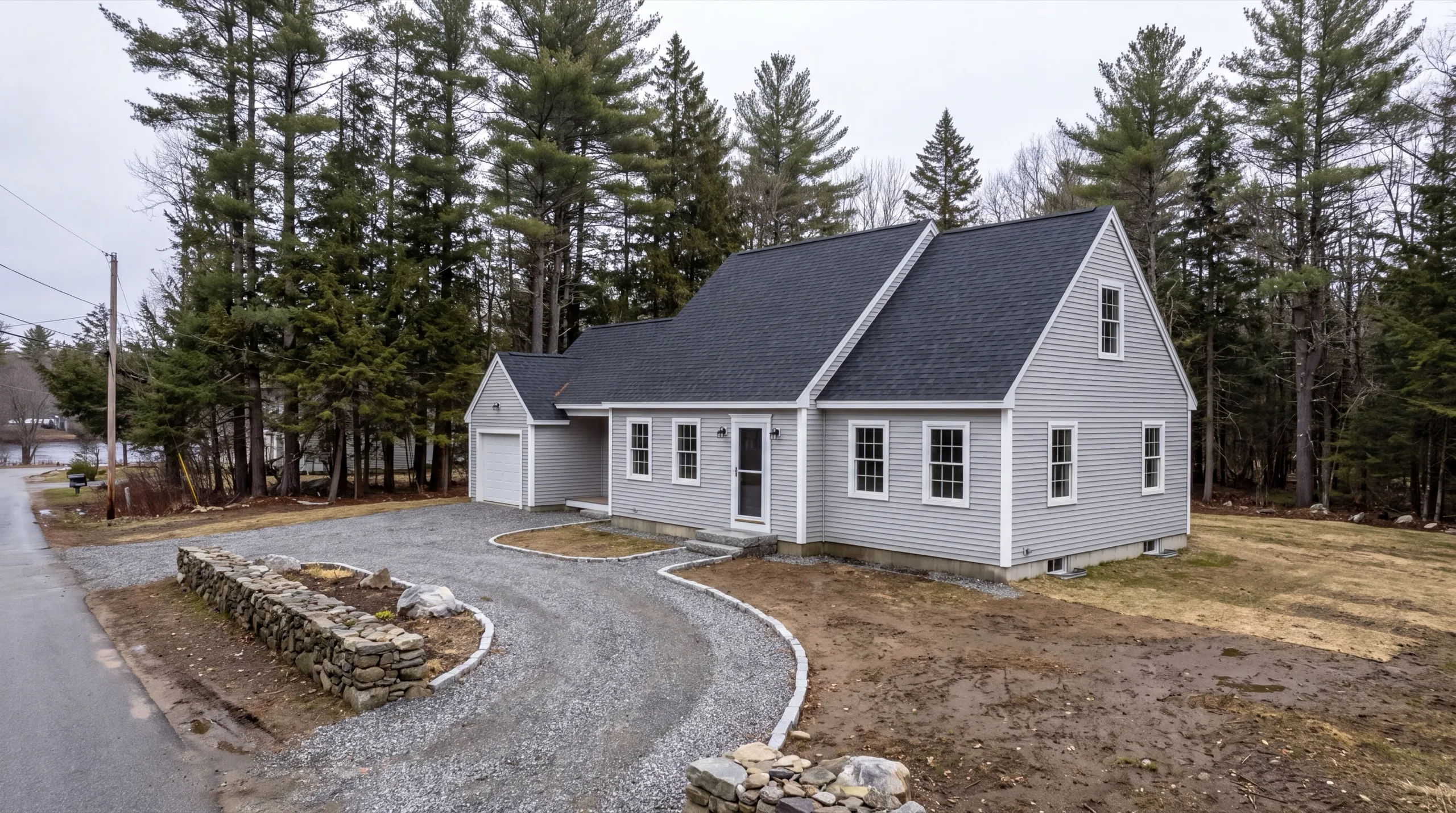 Siding contractor in Randolph, ME: finished gray cape with vinyl siding and an attached one-car garage