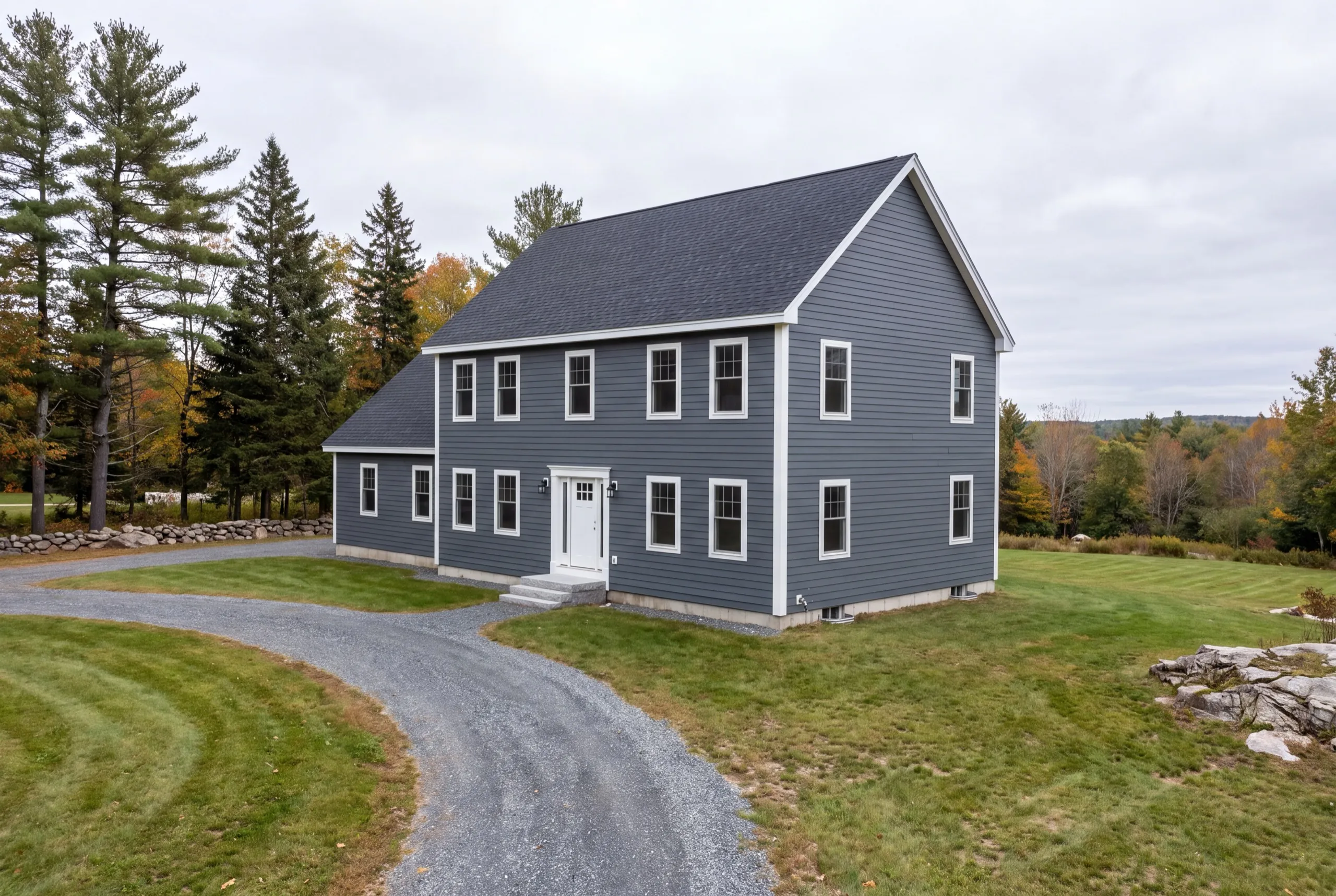 Siding contractor West Gardiner Maine: finished gray-blue lap-sided colonial with white trim and a curved gravel drive